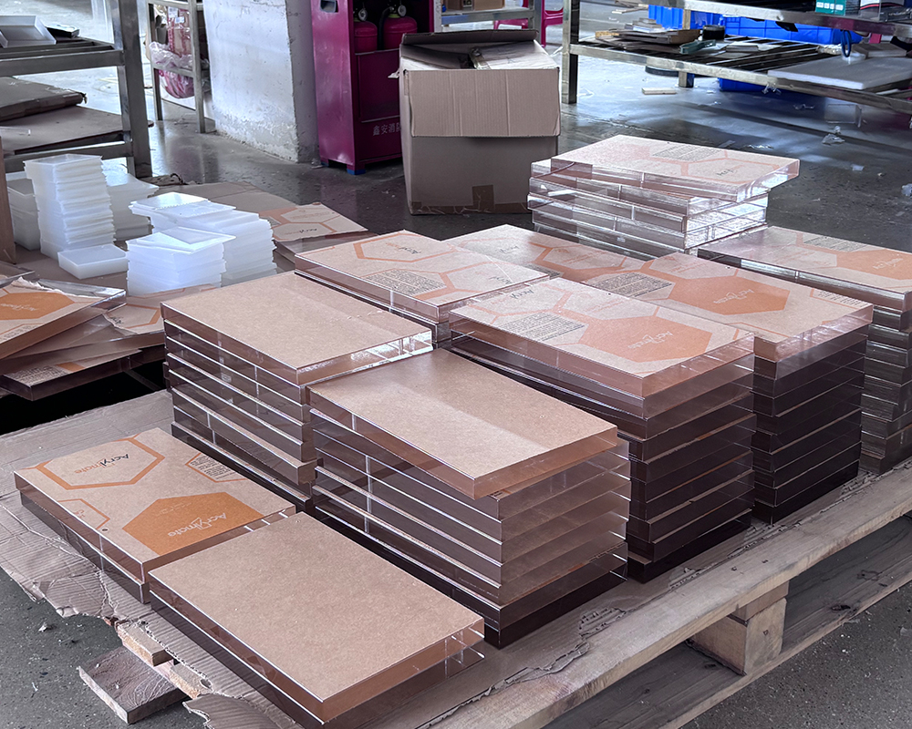 Neatly layered rectangular transparent acrylic sheets covered with brown protective kraft paper in warehouse