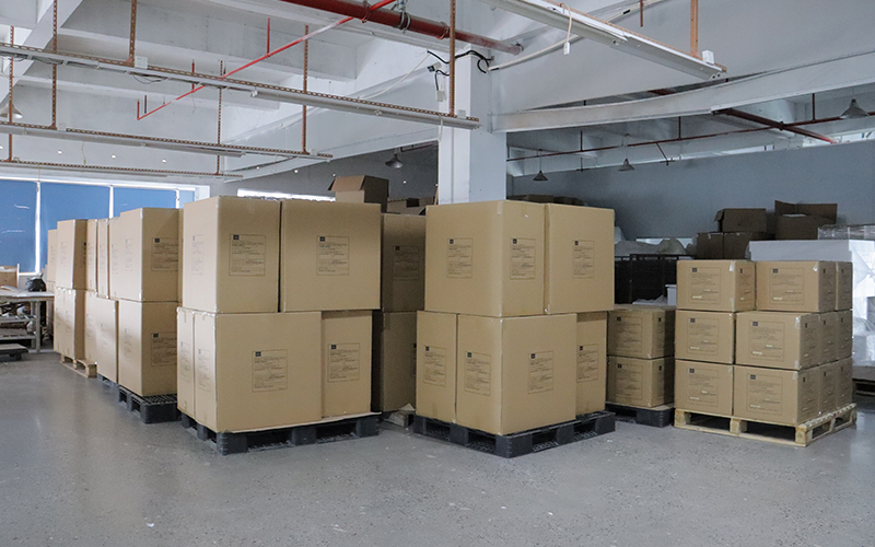 Neat stacked export cartons holding custom acrylic display goods in factory storage area