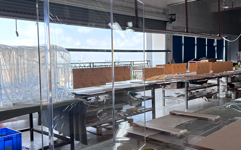 Tall large transparent acrylic partition wall raw panel in factory workshop with city window view