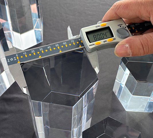 Digital caliper measuring acrylic thickness, strict quality control and precision tolerance for lucite manufacturing.