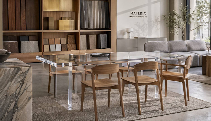 Minimalist luxury furniture showroom featuring a high-clarity acrylic dining table integrated with wood and upholstered furniture designs.