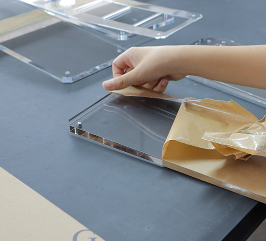 Peeling-off-kraft-paper-masking-from-precision-cut-clear-acrylic-sheet,-100%-virgin-MMA-high-transparency-lucite-for-bespoke-B2B-OEM-manufacturing.