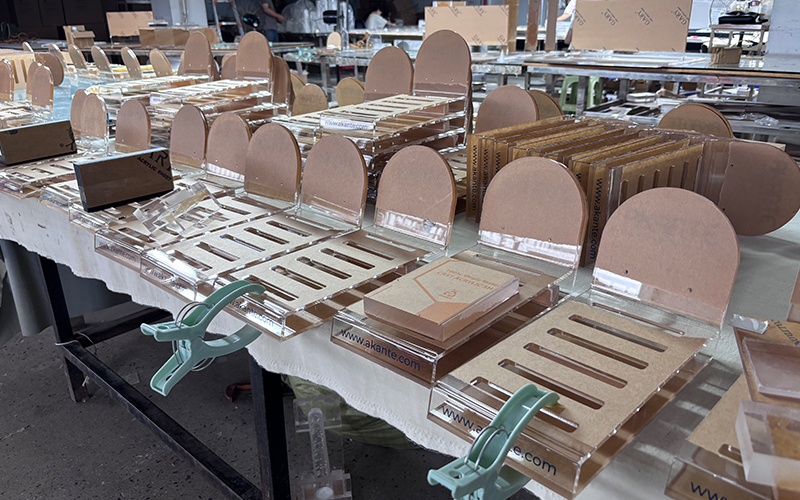 Precision assembly of acrylic tables using industrial-grade clamps, skilled solvent bonding and quality control for premium lucite products.