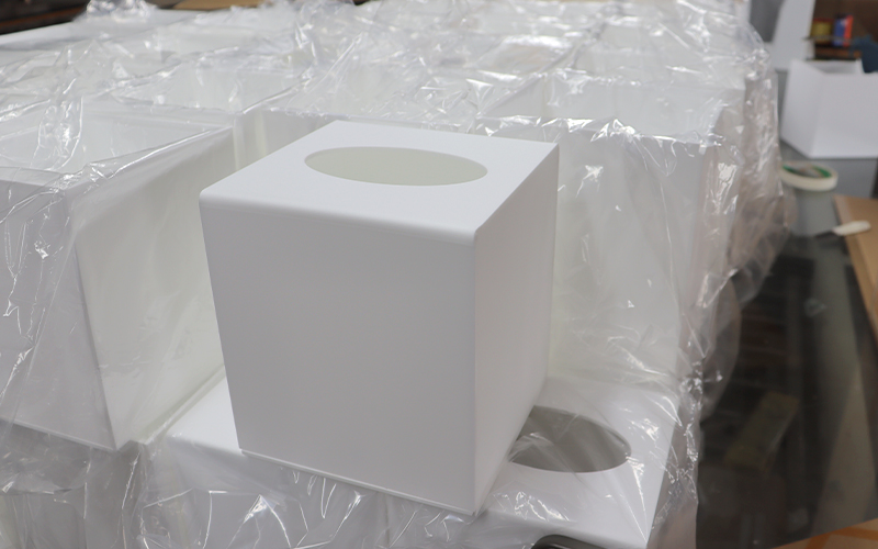 Precision laser-cut white acrylic tissue dispensers for hotel amenities