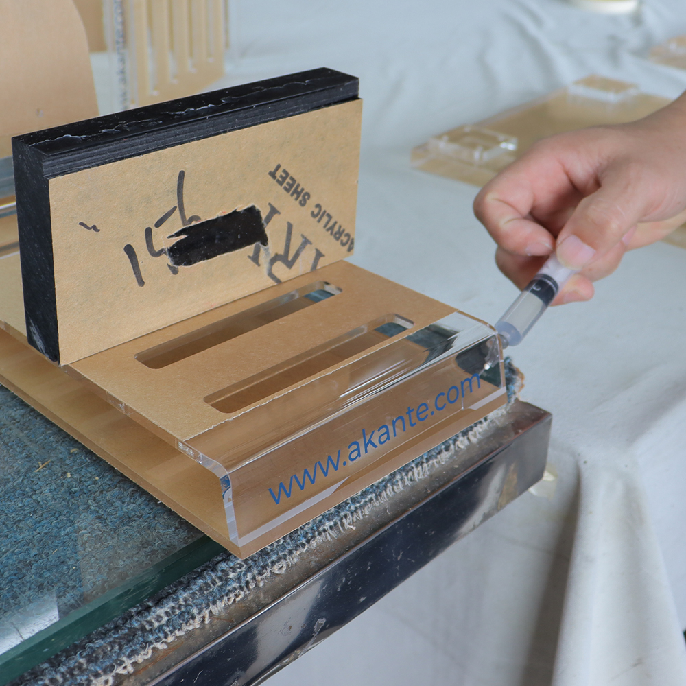 Precision solvent bonding of bespoke acrylic displays with custom silk-screened branding, ensured bubble-free by skilled technicians.