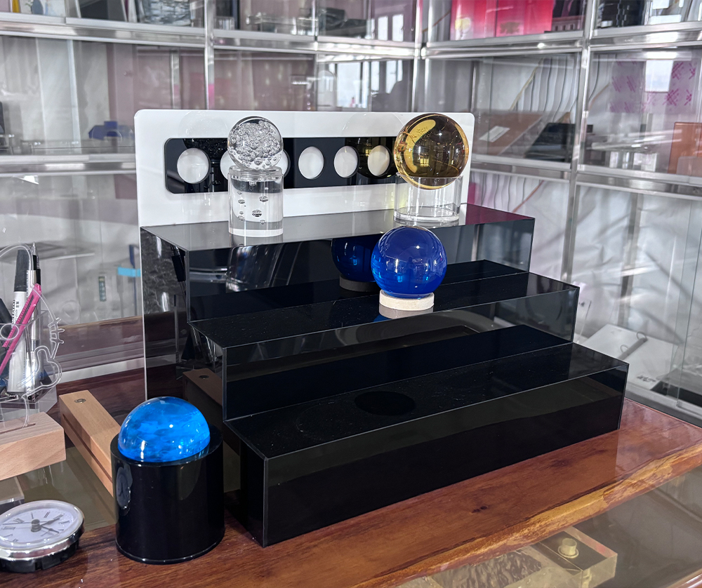 Black Tiered Acrylic Display Stand with Decorative Spheres and Raised Shelves