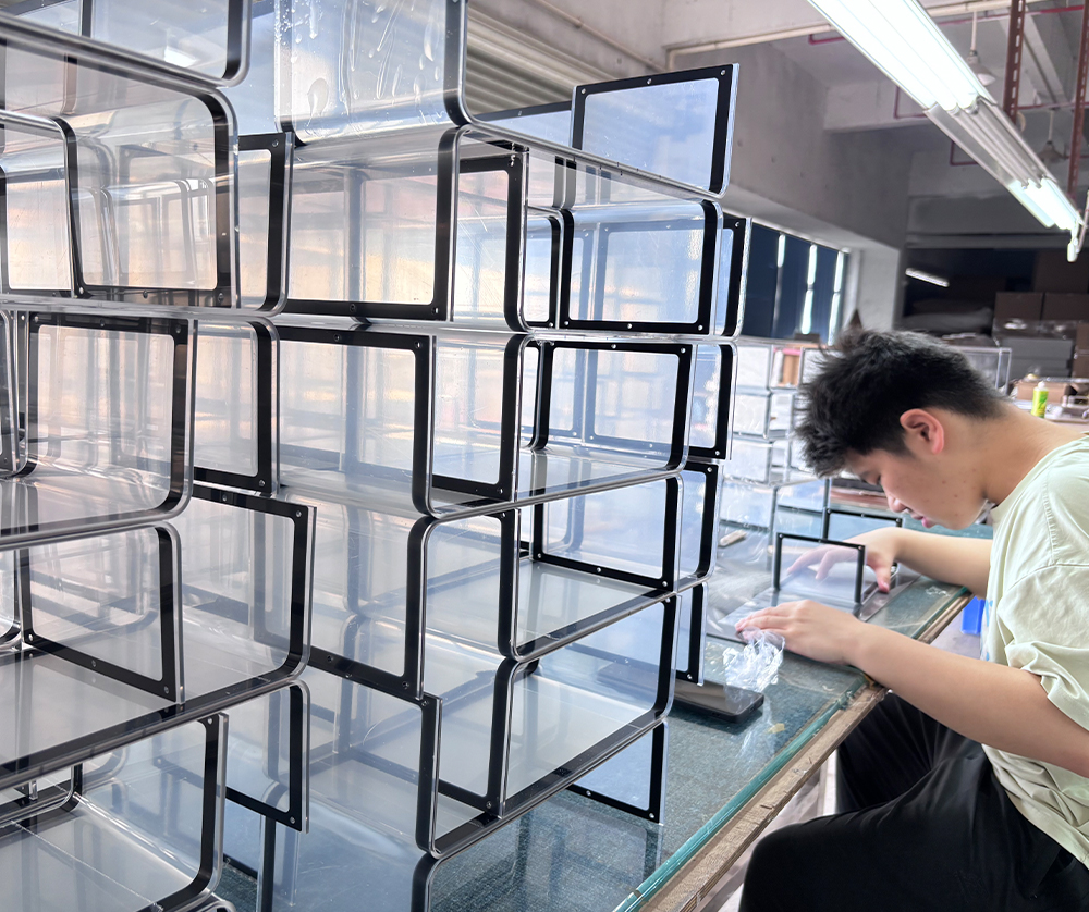 Black-framed Modular Acrylic Display Shelves Being Assembled in a Workshop