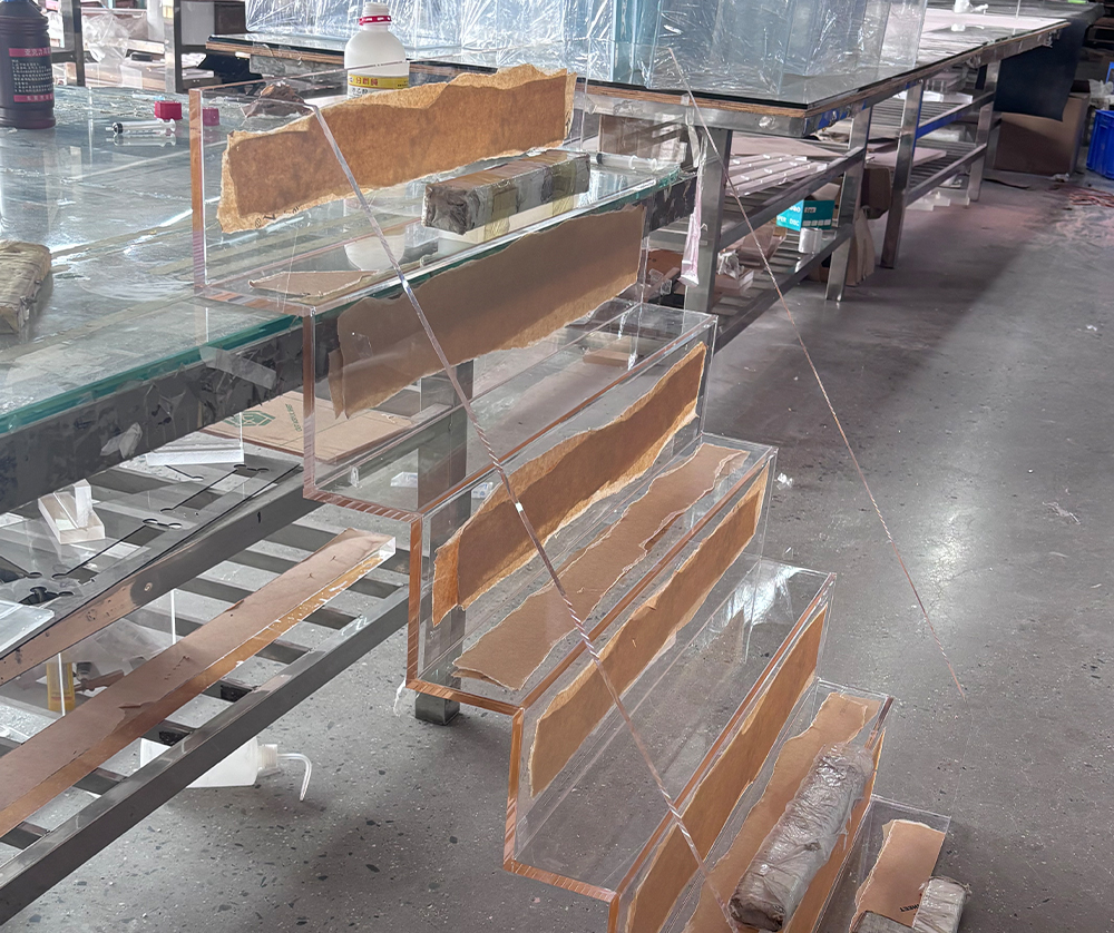 Clear Acrylic Tiered Display Stand with Protective Cardboard Inserts in a Factory