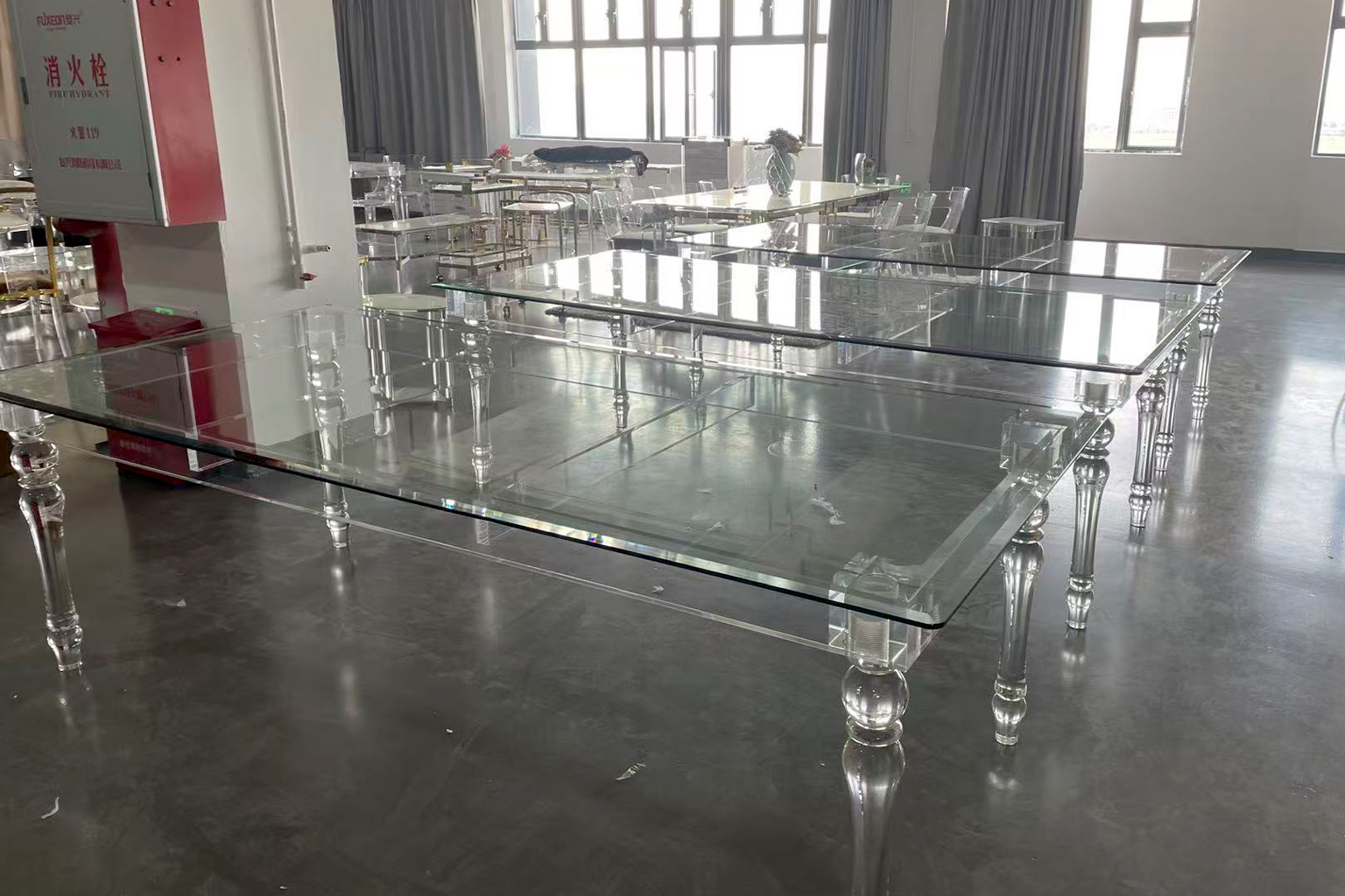 Large Clear Acrylic Dining Tables with Ornamental Legs in a Furniture Showroom