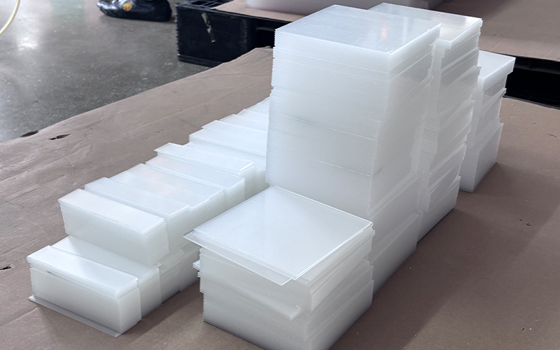 Stacked Frosted White Acrylic Panels and Cut Components Ready for Assembly