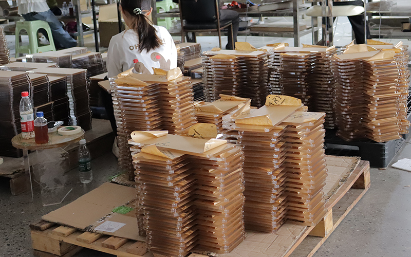 Stacked Kraft-paper-protected Acrylic Panels Prepared for Batch Processing
