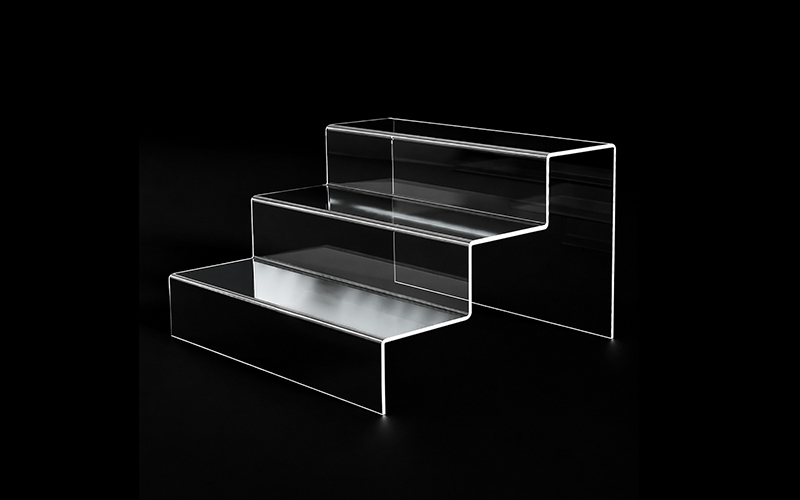 Three-tier Clear Acrylic Step Display Stand with Raised Back Panels on a Black Background