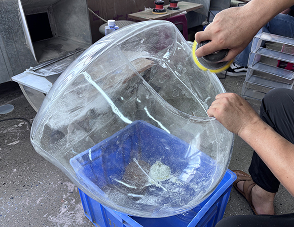 Worker Polishing a Clear Acrylic Pet Enclosure with a Handheld Tool