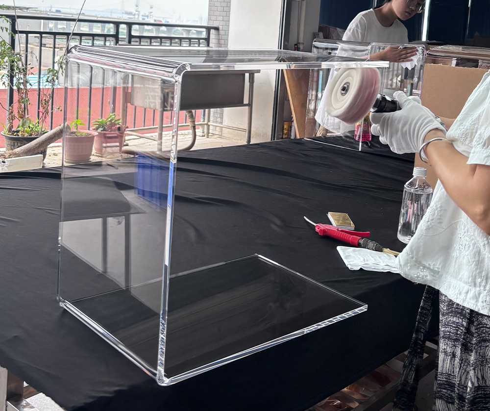 Worker Polishing a Large Clear Acrylic Display Case with a Buffing Wheel