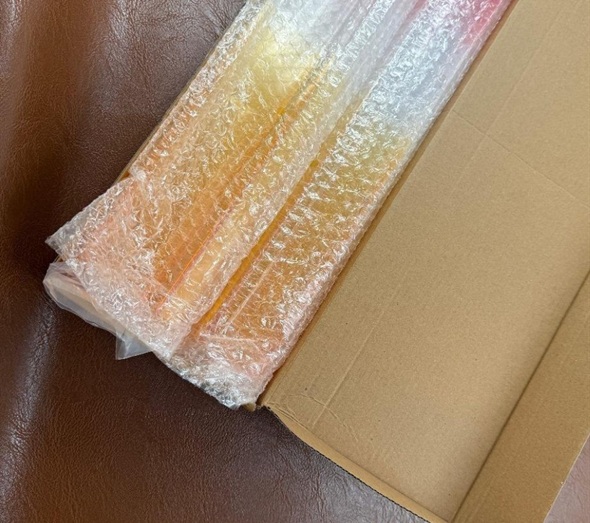 Acrylic mahjong racks in protective bubble wrap inside carton