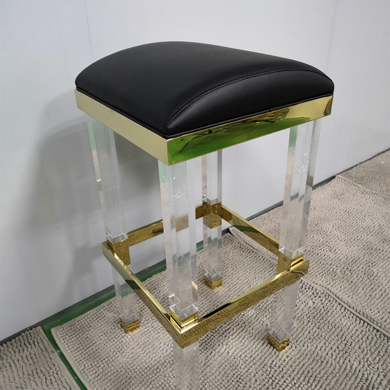 Black cushioned acrylic stool with gold metal frame