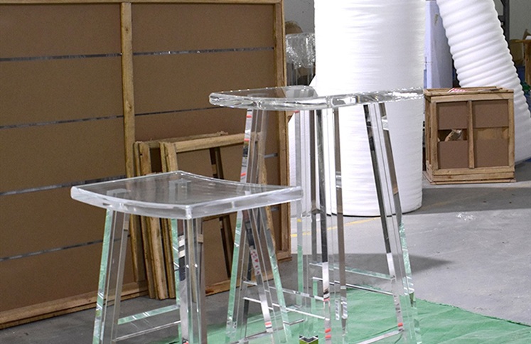 Clear acrylic bar stools in factory packing area