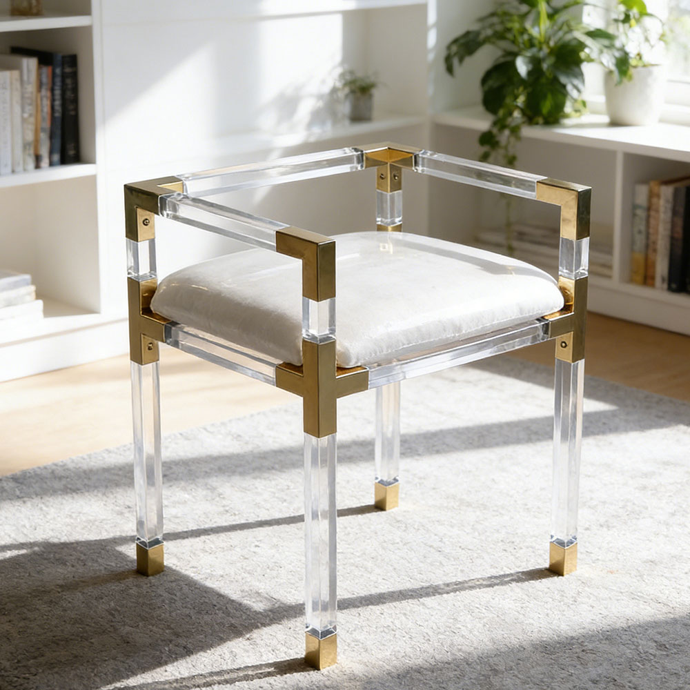 Clear acrylic chair with gold accents and white cushion