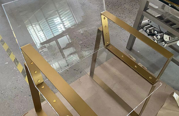 Clear acrylic chair with gold metal frame and arms