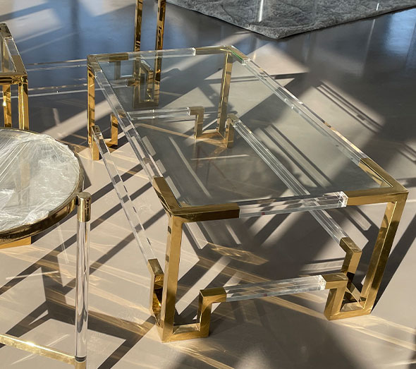 Clear acrylic coffee table with gold metal accents