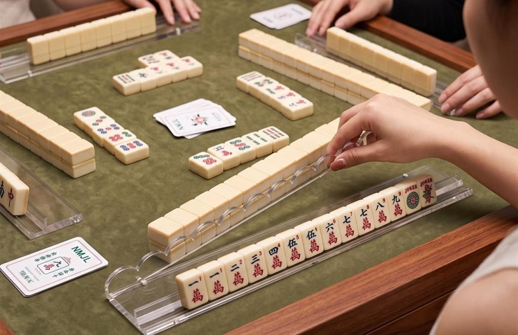 Clear acrylic mahjong racks and pushers on green gaming table