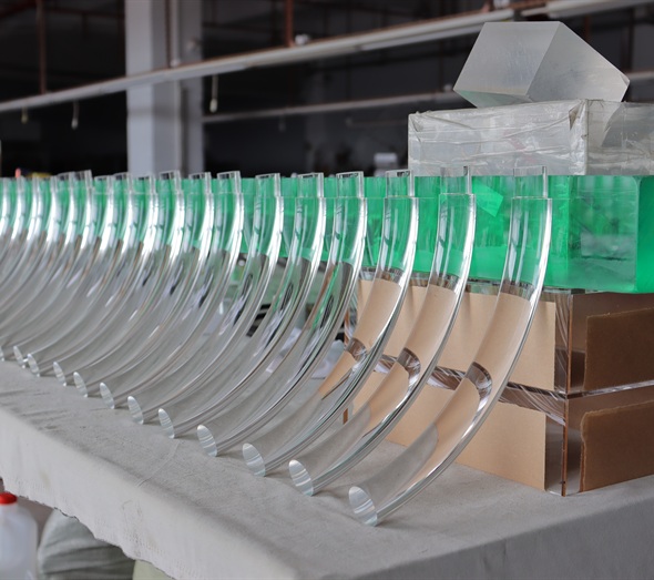 Curved clear acrylic components arranged for production