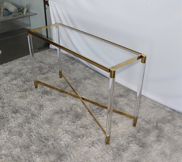 Glass top console table with brass frame and acrylic legs on rug