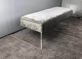 Grey velvet upholstered bench with clear acrylic panel legs