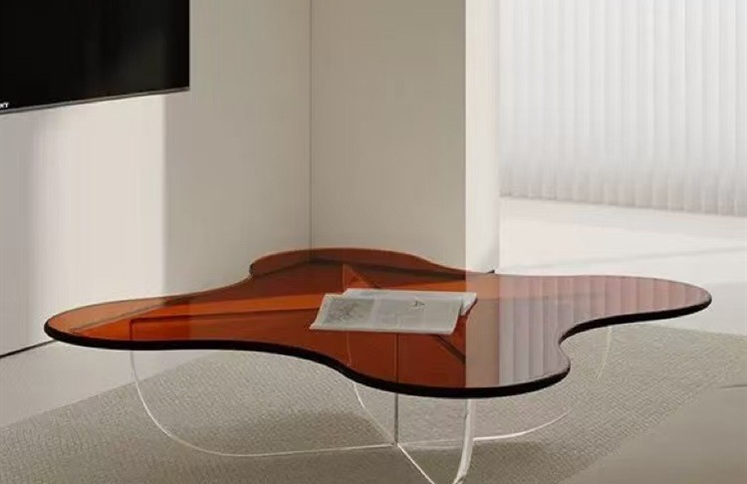 Irregular amber acrylic coffee table with clear cross base
