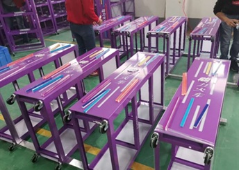 Purple acrylic rolling workstations in factory assembly line