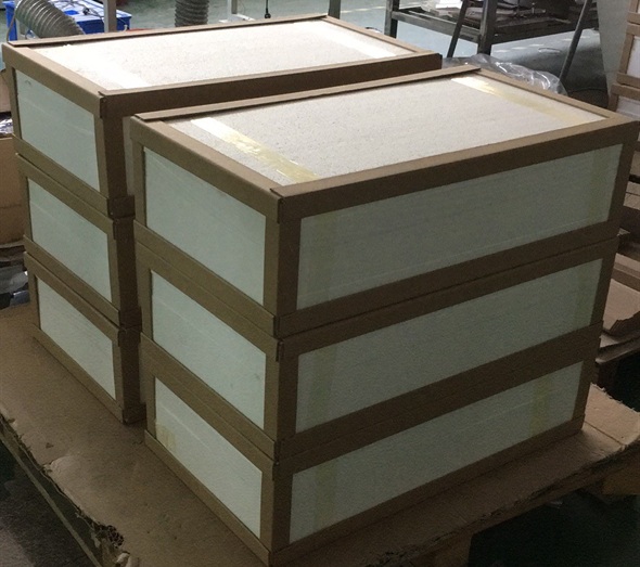 Reinforced packaging boxes stacked on wooden pallet in workshop