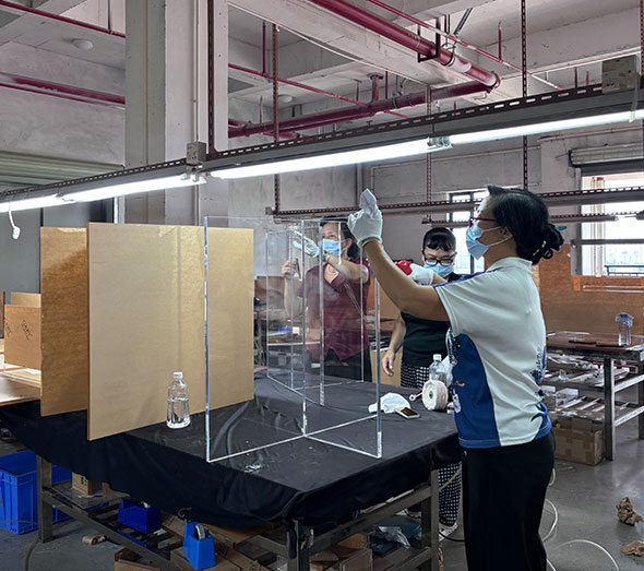 Worker inspecting clear acrylic furniture in factory