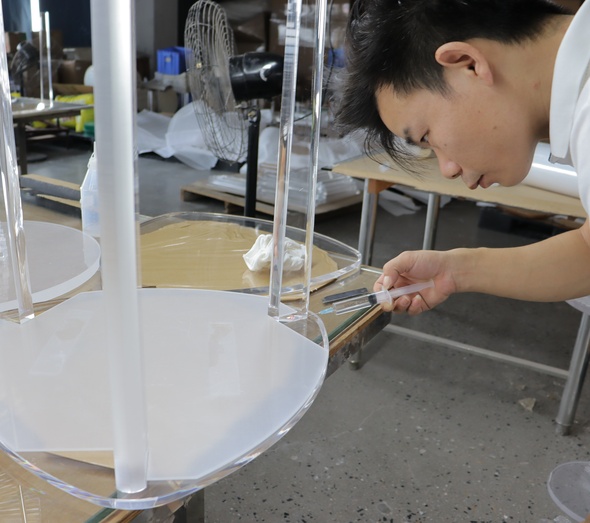 craftsman-injecting-adhesive-acrylic-table-leg-joint-workshop